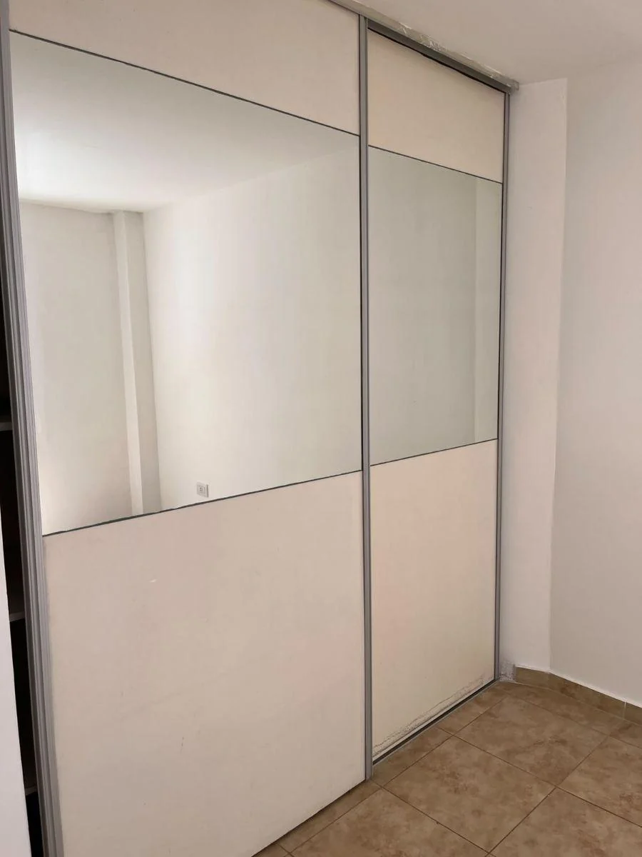 Placard del dormitorio con puertas corredizas y espejo.